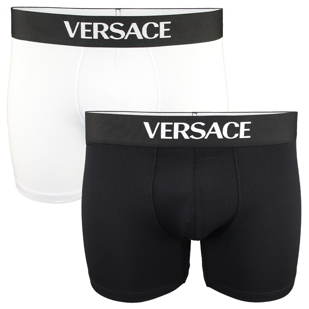 Two pairs of Versace boxer briefs, one black and one white, on a white background.