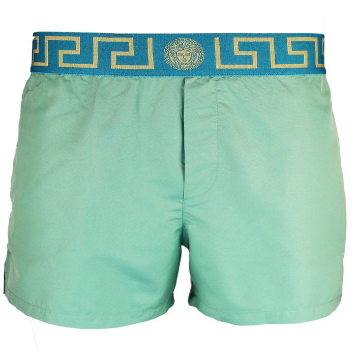 Green swim shorts with a decorative blue and gold waistband on a white background