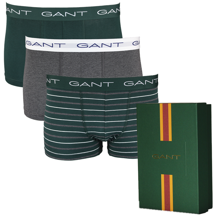 Three pairs of Gant boxer trunks in different styles with a Gant branded box on a white background.