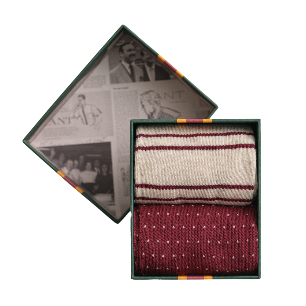 Two pairs of patterned Gant socks in a decorative box with vintage-style newspaper background