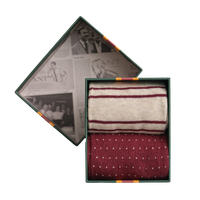 Two pairs of patterned Gant socks in a decorative box with vintage-style newspaper background
