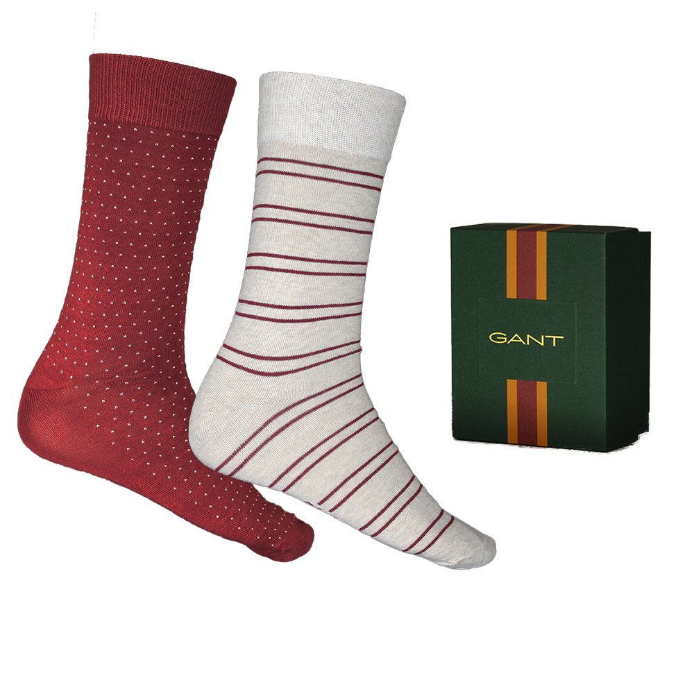 Two pairs of socks with red and white patterns next to a Gant box on a white background