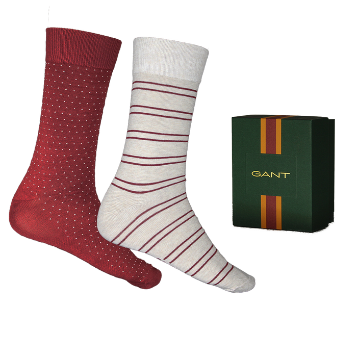 Two pairs of socks with red and white patterns next to a Gant box on a white background