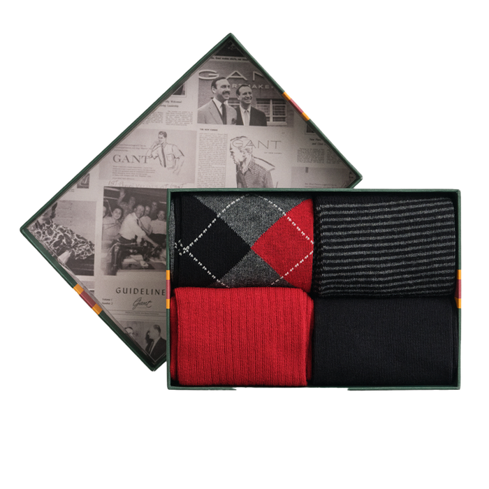 Set of three socks in a decorative box with a newspaper design on the lid.