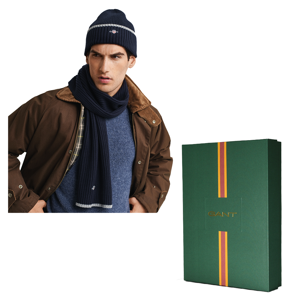 Man wearing a brown jacket, blue scarf, and navy beanie with a GANT branded box on a white background.