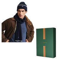 Man wearing a brown jacket, blue scarf, and navy beanie with a GANT branded box on a white background.