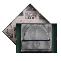 Gray beanie with navy band in a decorative box with newspaper design