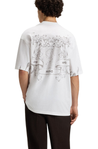 Person wearing a white t-shirt with black graphics and text, standing against a white background