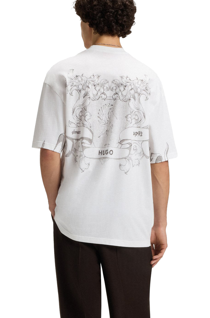 Person wearing a white t-shirt with black graphics and text, standing against a white background