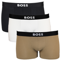 Three pairs of BOSS branded boxer trunks in black, white, and beige on a white background.