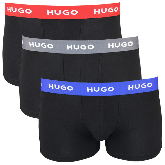 Three black boxer trunks with colorful 'HUGO' brand bands on a white background