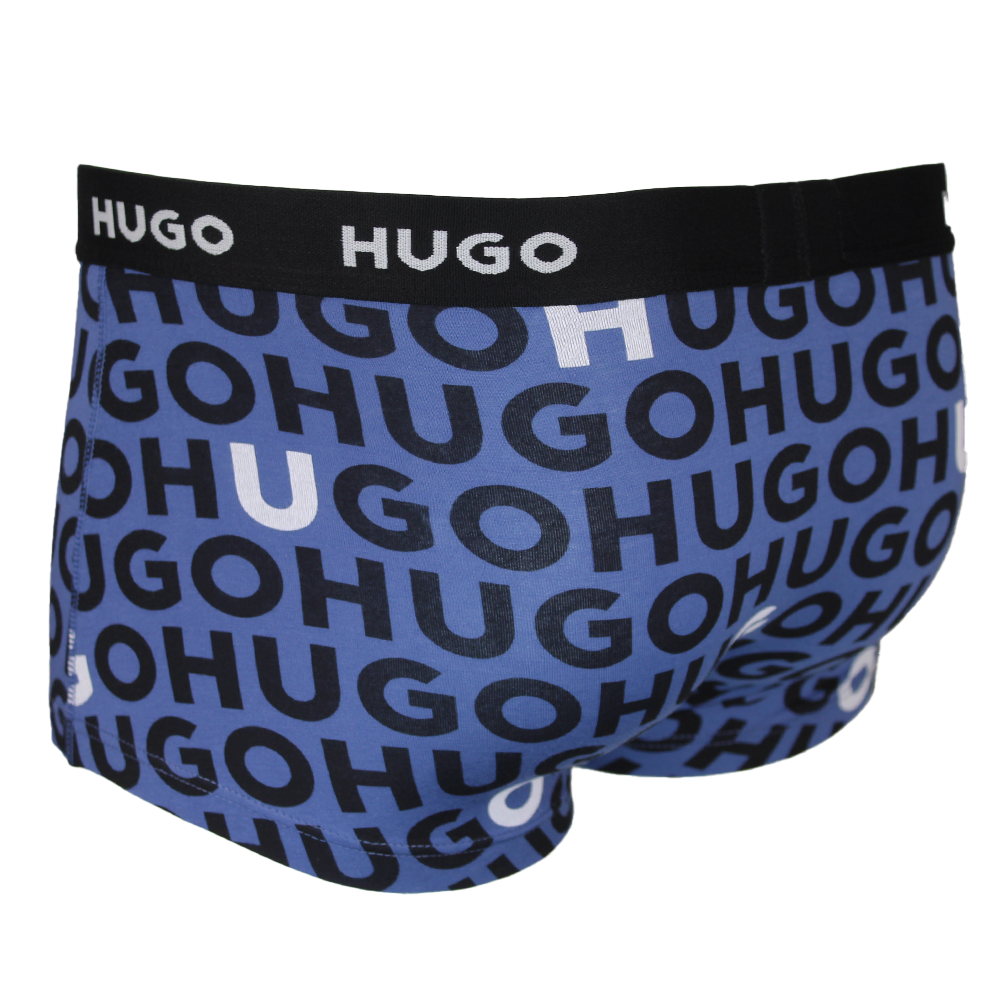 Blue boxer trunks with black 'HUGO' logo pattern on a white background
