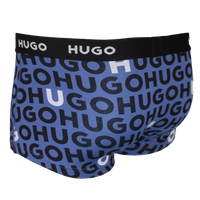 Blue boxer trunks with black 'HUGO' logo pattern on a white background