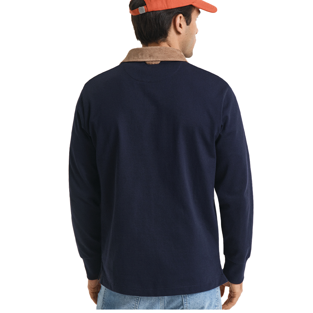 Back of man wearing a navy long-sleeve polo shirt with a brown collar, orange cap, and blue jeans on a white background.