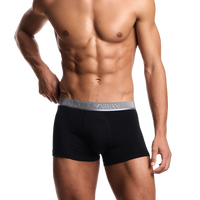 a model wearing black Armani boxer trunks with branded silver waistband