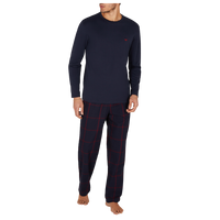 Man wearing navy long-sleeve top and pants with red plaid pattern on a white background