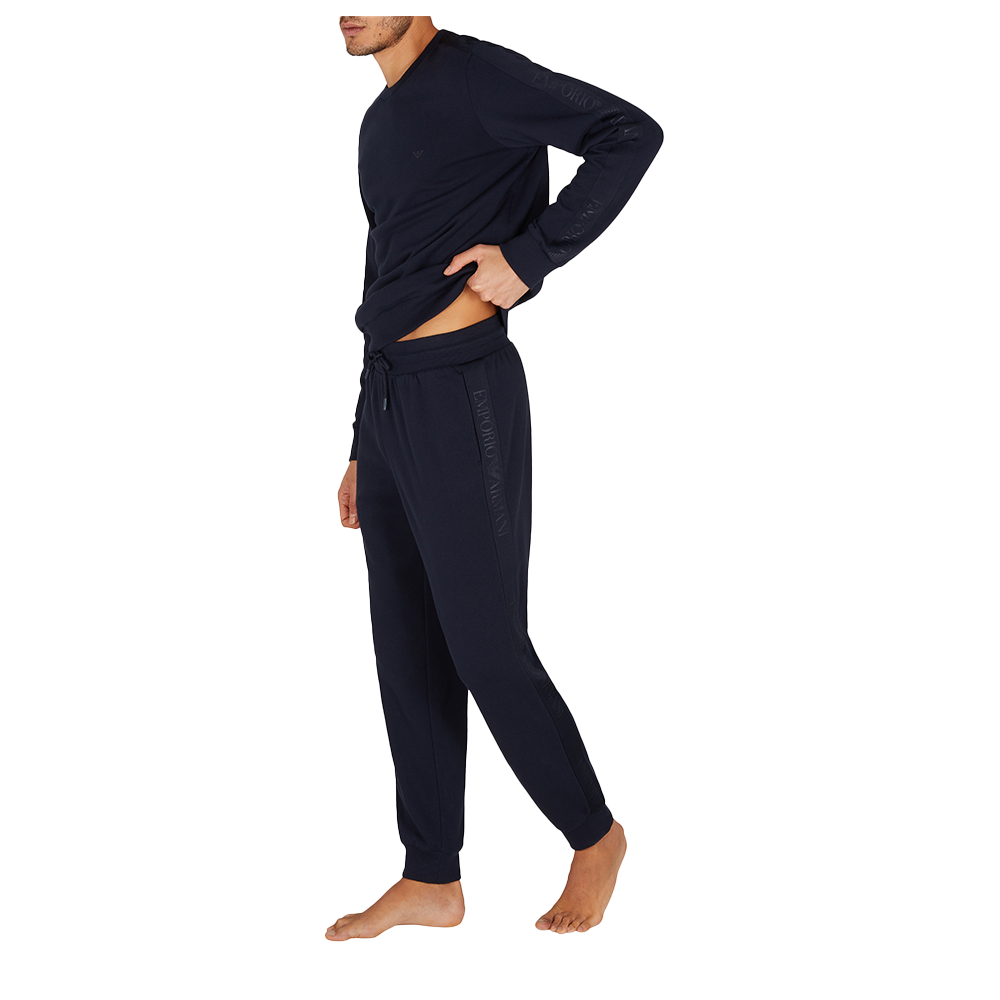 Person wearing a navy tracksuit on a white background