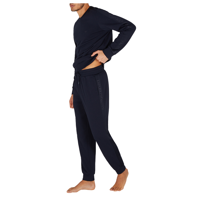 Person wearing a navy tracksuit on a white background