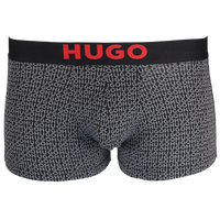 Black boxer trunks with red 'HUGO' logo on waistband on a white background