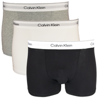 Three Calvin Klein boxer trunks in black, gray, and white on a white background.