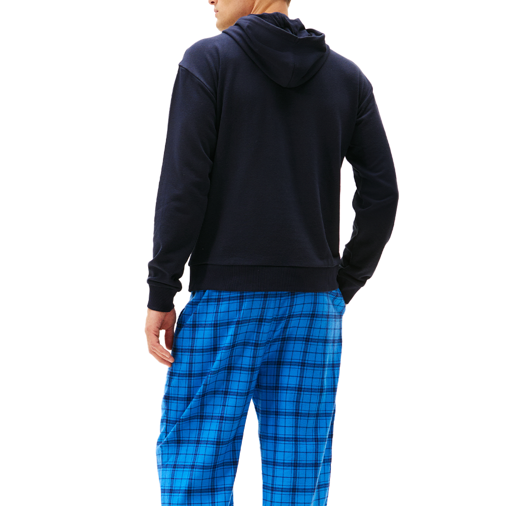 Person wearing a navy hoodie and blue plaid pants on a white background