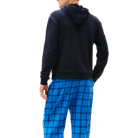 Person wearing a navy hoodie and blue plaid pants on a white background