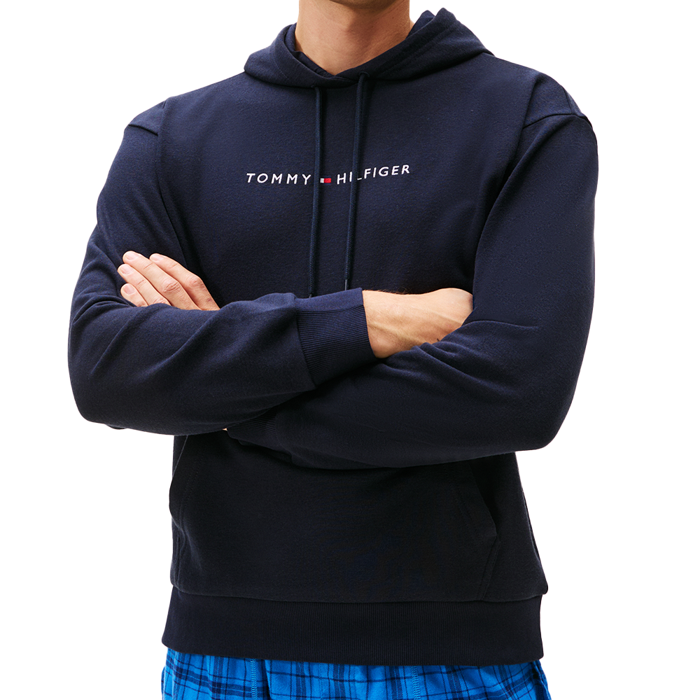 Navy hoodie with Tommy Hilfiger logo worn by a person on a white background