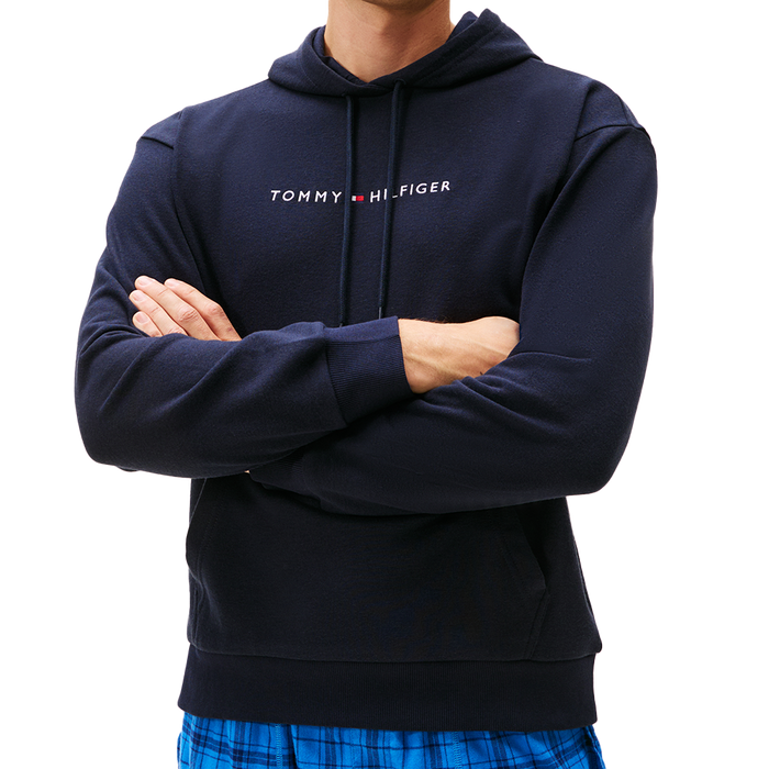 Navy hoodie with Tommy Hilfiger logo worn by a person on a white background